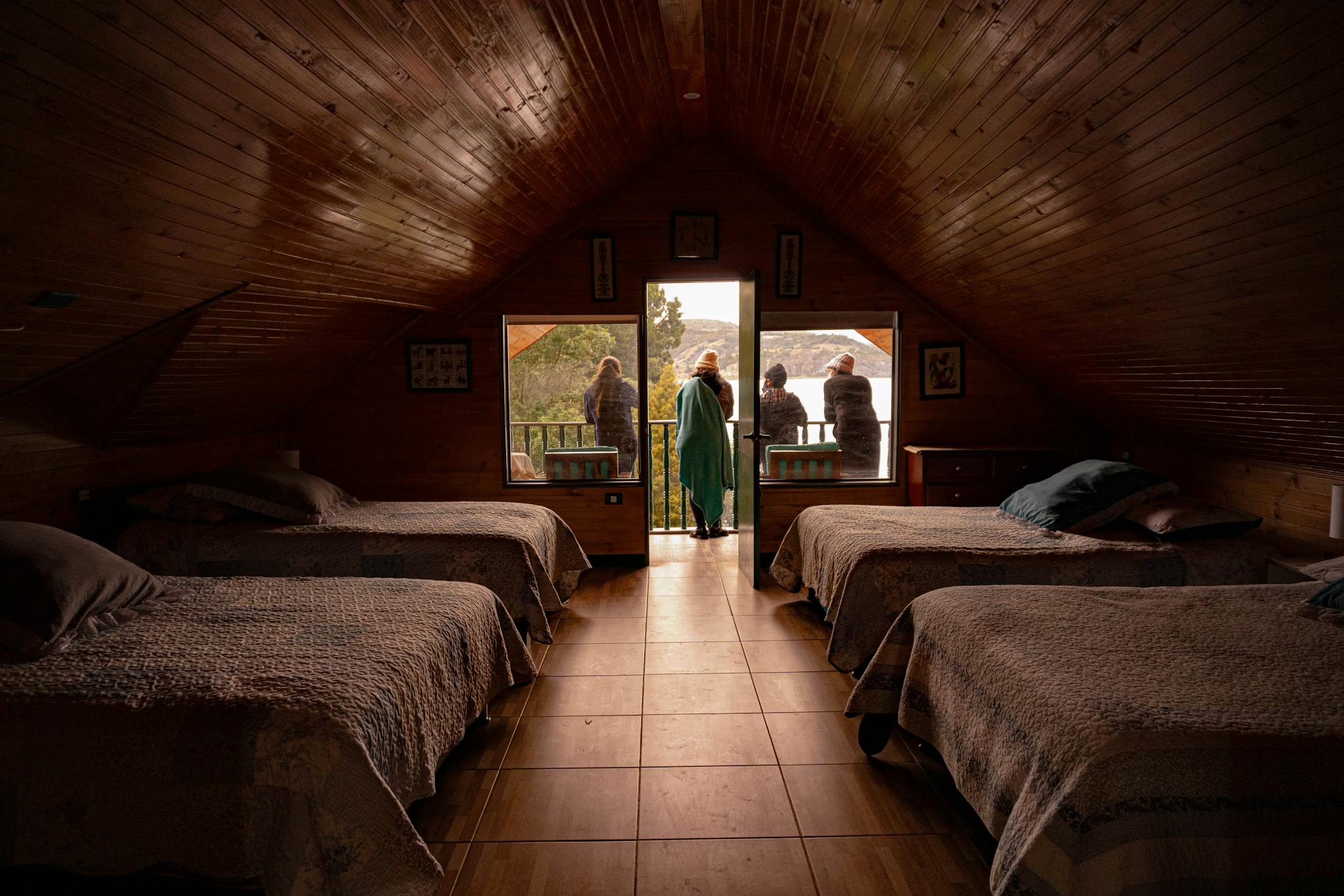 Warm attic room with wooden decor and balcony view in Aquitania, Colombia.